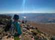 Incredible scenic photo of cyclist overlooking a beautiful valley in South Africa and the dams below in the distance - Outland Travel