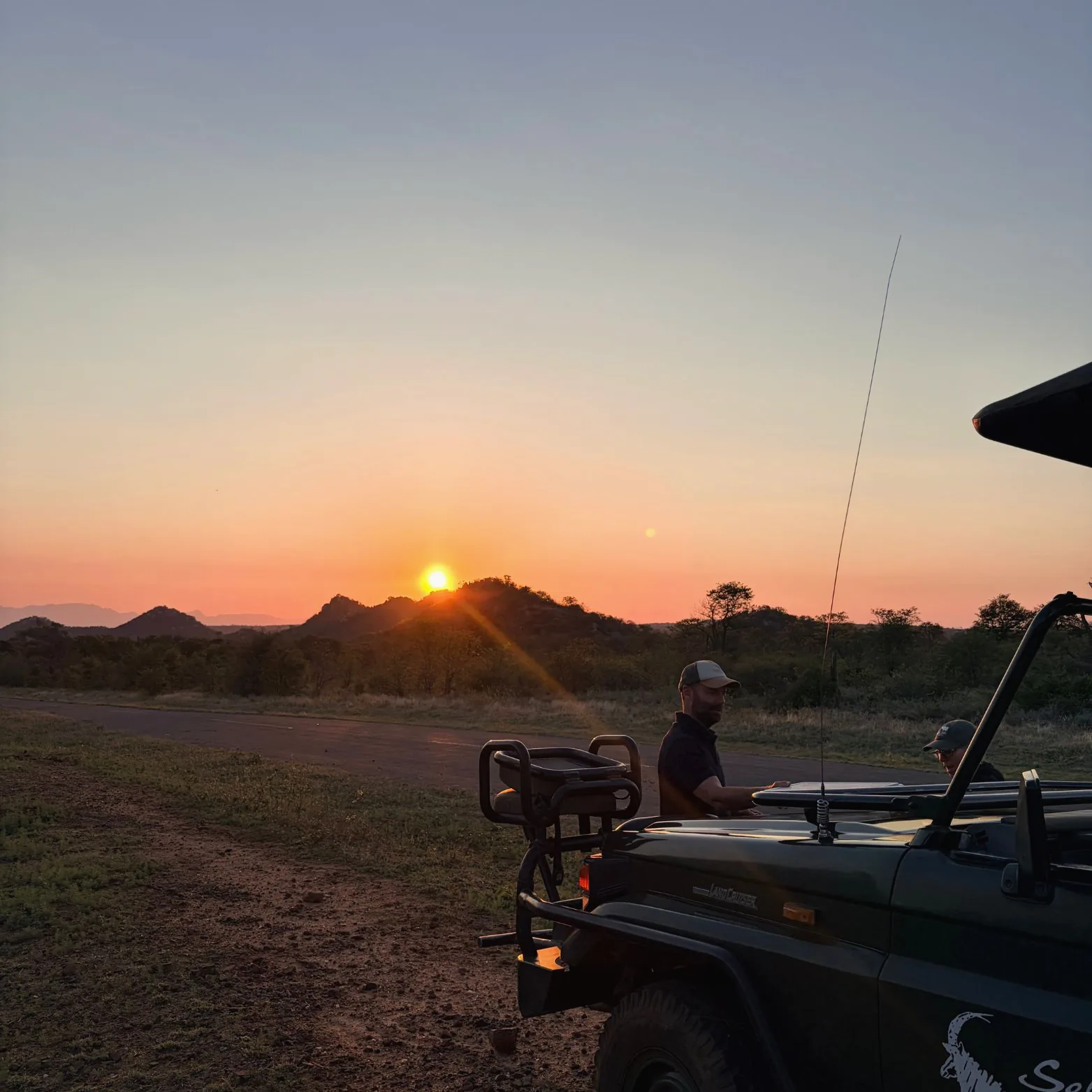 Outland Travel guides beside an open safari vehicle in the Selati Game Reserve as the sun rises over the hills.